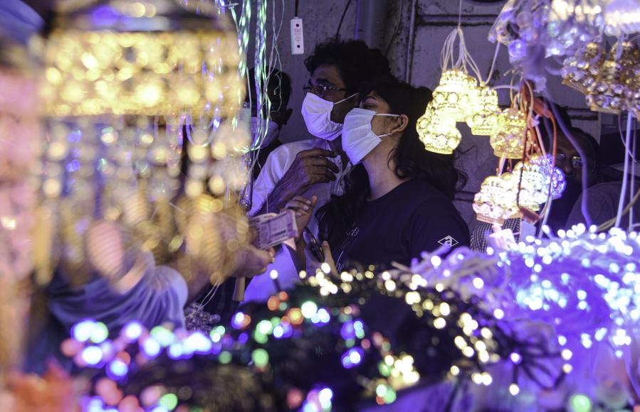 Personas observan luces eléctricas previo al festival Diwali en Mumbai, India