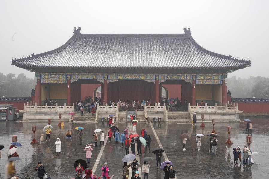Turistas visitan Parque Tiantan durante una nevada en Beijing