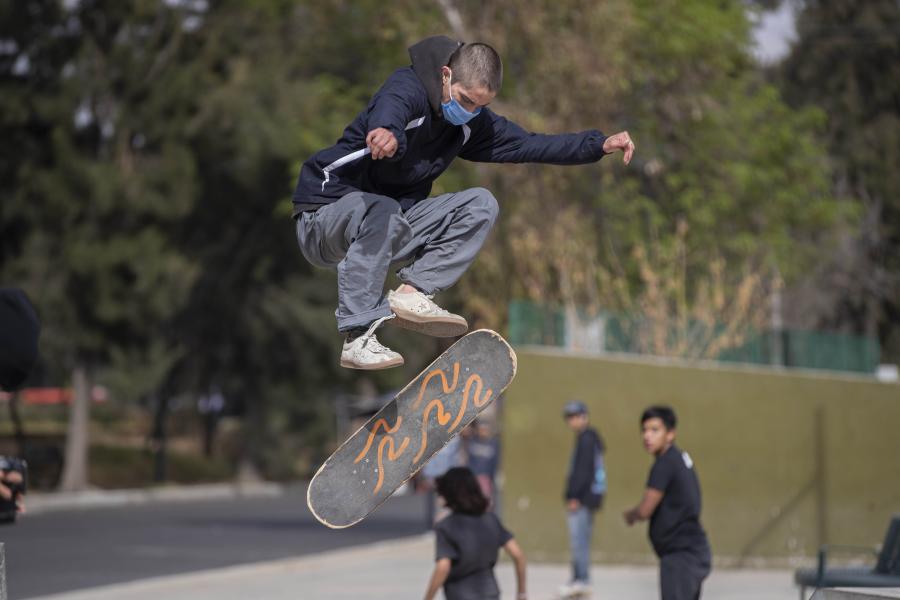 Jóvenes realizan acrobacia en patineta en Bosque de San Juan de Aragón en la Ciudad de México