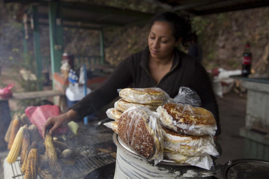 Mujer prepara elotes y postres tradicionales de maíz para su venta en Honduras