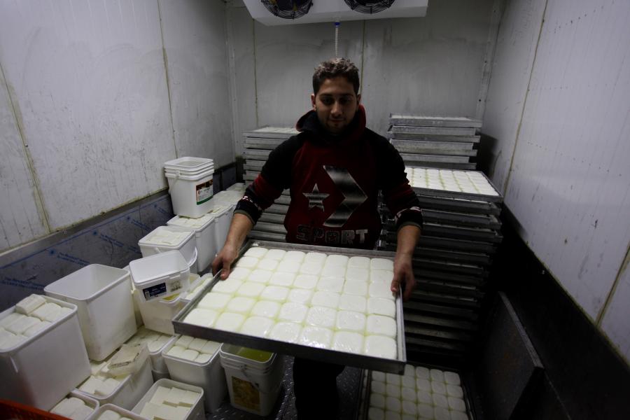 Trabajador palestino elabora queso en taller en aldea de Rojeeb