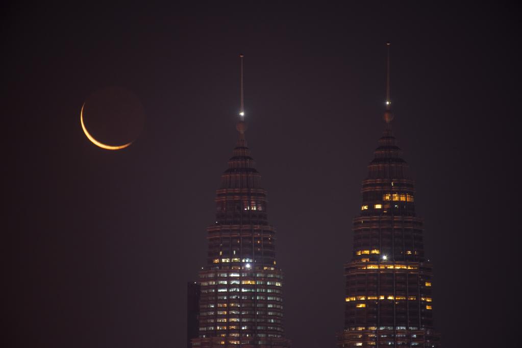 Luna creciente en cielo sobre la ciudad de Kuala Lumpur, Malasia