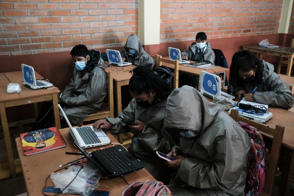 Alumnos toman clases en línea con computadoras y teléfonos celulares donados en Bolivia