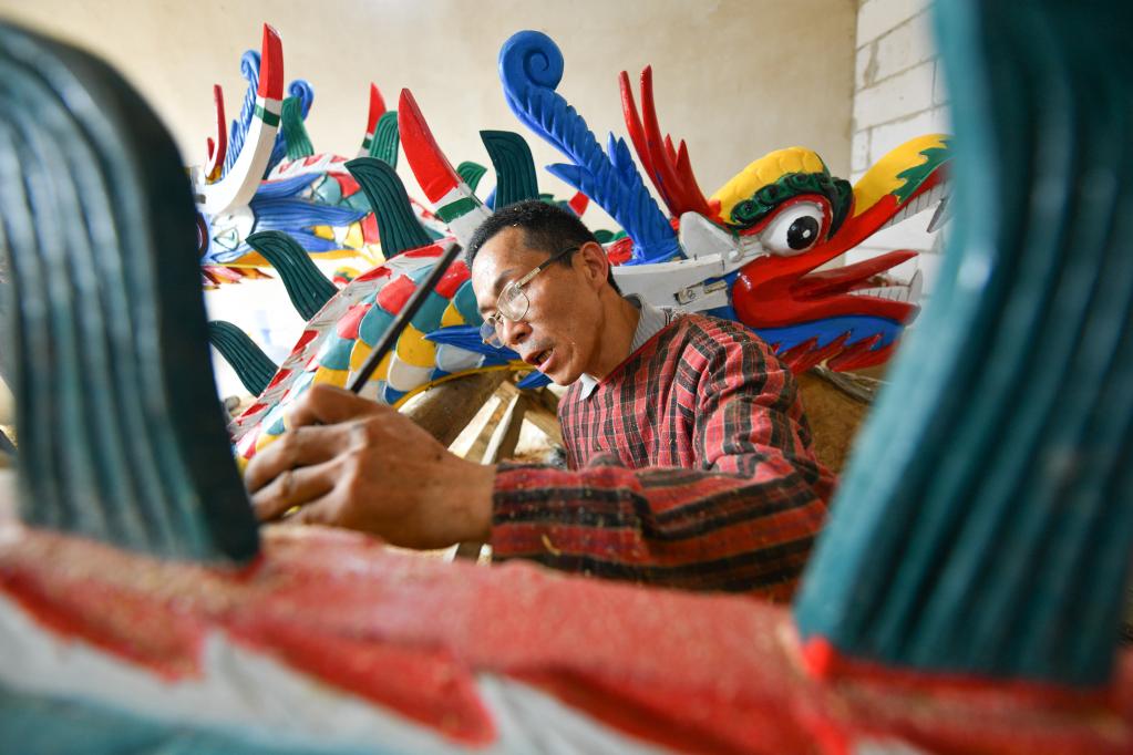 Artesanos se encuentran ocupados fabricando cabezas de dragón en municipio de Chengguan, Guizhou