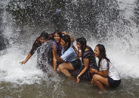 Personas se bañan en cascada para vencer calor en Tokha, Nepal