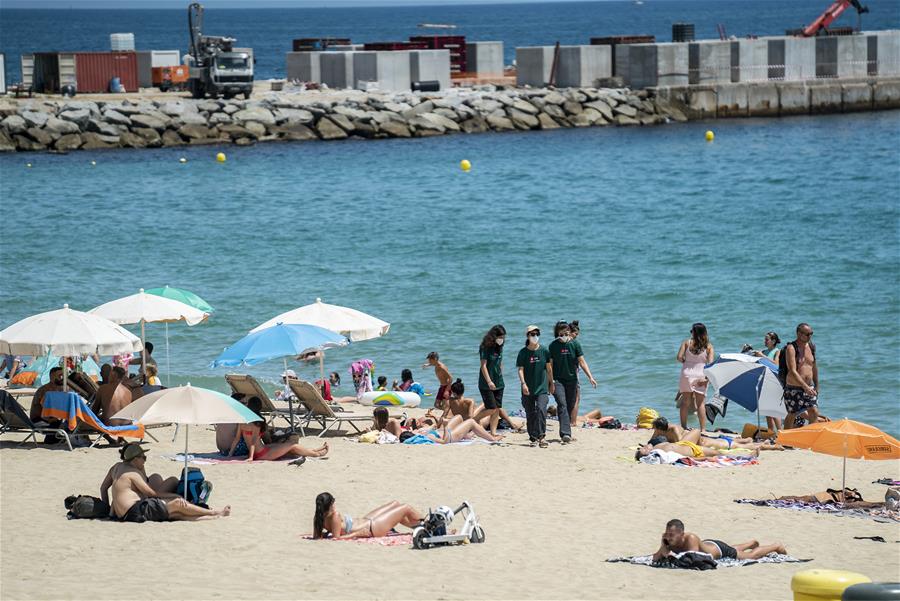 España: Empleados comunitarios en playa en Barcelona